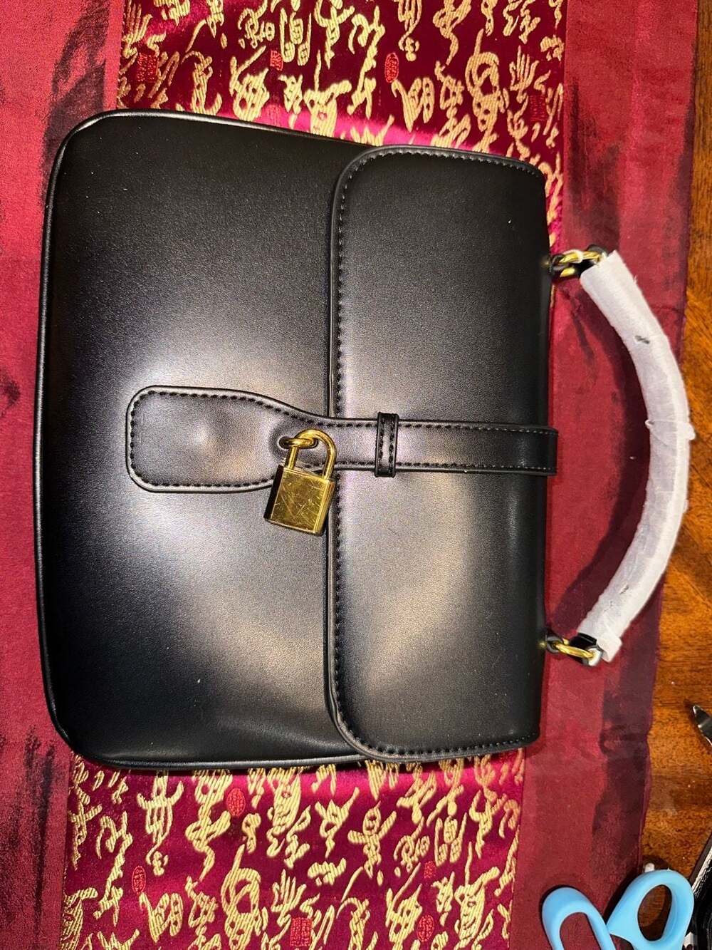 Black Leather Top Handle Handbag with Gold-Tone Padlock and Strap Closure